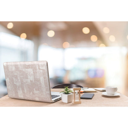 A modern workspace with a laptop, potted plants, an hourglass, a phone, a notebook with a pen, and a cup and saucer on a wooden table. The background features softly blurred blush tones and Nikki Chu Capetown Peel and Stick Wallpaper from WallPops with geometric design, enhanced by warm lights that create a cozy, inviting atmosphere.