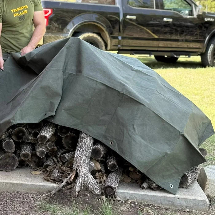 Olive Drab 6' x 8' canvas tarp shielding stacked logs from outdoor weather exposure