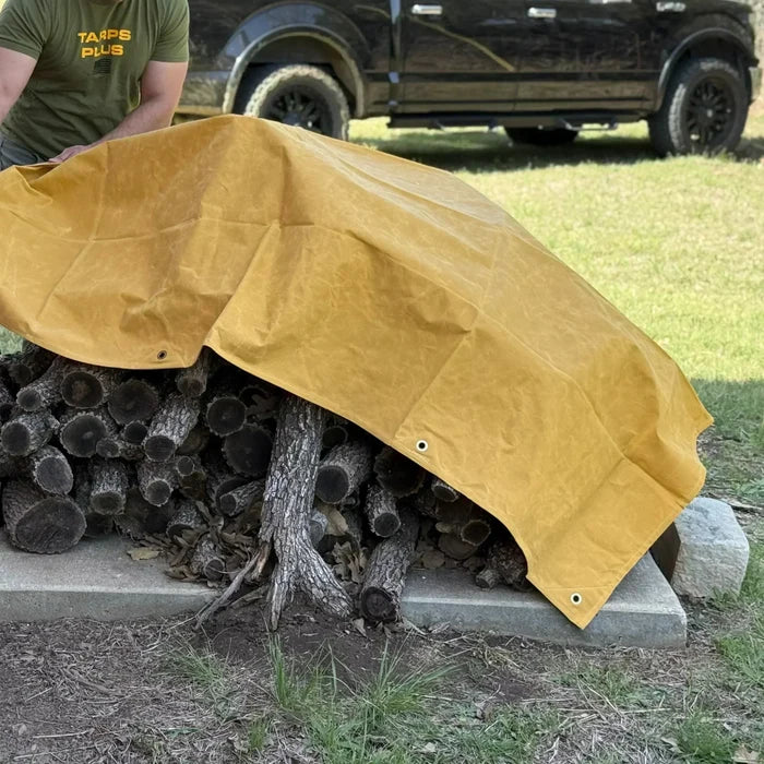 Tan 16' x 20' canvas tarp covering outdoor woodpile storage for weather protection